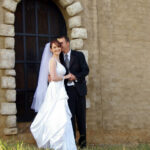 Bride and groom pose in arch
