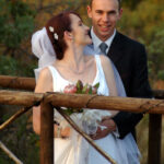 Groom holds bride on bridge