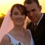 Sun sets behind bride and groom