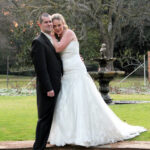 Bride and groom by water fountain