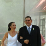 Bride and groom walk through mist