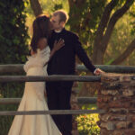 Bride and groom kiss on bridge