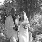 Bride and groom walk through flower garden