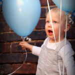 Boy and balloons at first birthday